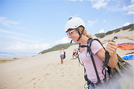 parachute, beach - Smiling female paraglider with equipment on beach Stock Photo - Premium Royalty-Free, Code: 6113-09168483
