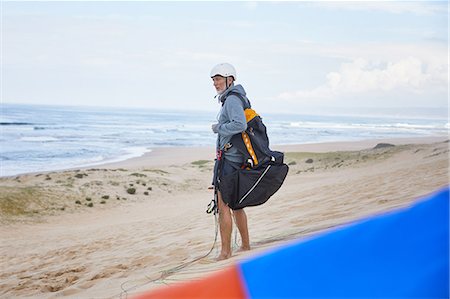 parachute, beach - Paraglider with parachute backpack on ocean beach Stock Photo - Premium Royalty-Free, Code: 6113-09168480