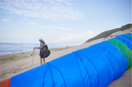 parachute, beach - Male paraglider with parachute on ocean beach Stock Photo - Premium Royalty-Free, Code: 6113-09168489