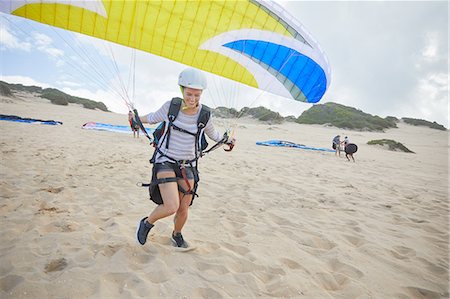 parachute, beach - Female paraglider with parachute running, taking off on beach Photographie de stock - Premium Libres de Droits, Code: 6113-09168495