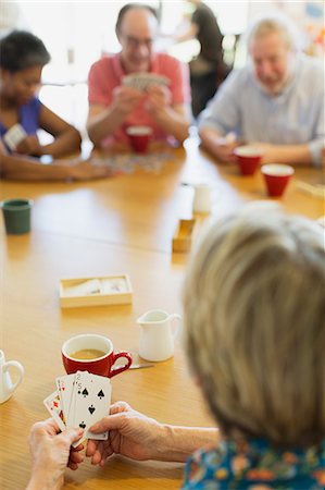 senior, playing cards - Senior friends playing cards at table in community center Stock Photo - Premium Royalty-Free, Code: 6113-09168413