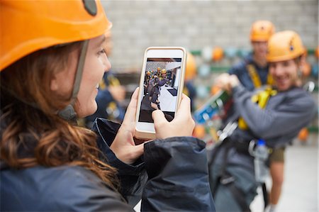 simsearch:6113-09168548,k - Woman with camera phone photographing friends in zip line equipment Stock Photo - Premium Royalty-Free, Code: 6113-09168546