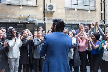 simsearch:695-03376535,k - Business people cheering for businessman in courtyard Stock Photo - Premium Royalty-Free, Code: 6113-09168565