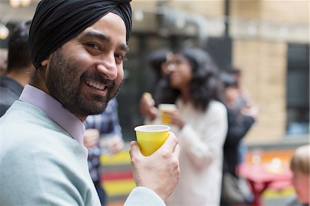simsearch:6113-07543029,k - Portrait smiling man in turban drinking, enjoying party Stock Photo - Premium Royalty-Free, Code: 6113-09168582