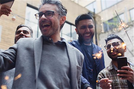 fun reading - Enthusiastic male friends celebrating with sparklers Stock Photo - Premium Royalty-Free, Code: 6113-09168596