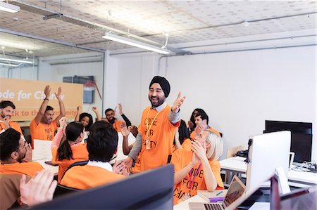 Enthusiastic hackers cheering, coding for charity at hackathon Stock Photo - Premium Royalty-Free, Code: 6113-09168642