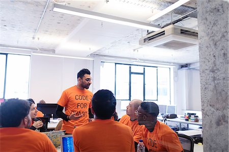 people talking candid not business not smiling - Hacker leading discussion, coding for charity at hackathon Stock Photo - Premium Royalty-Free, Code: 6113-09168646