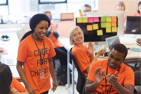 simsearch:6113-09168615,k - Hackers clapping for woman, coding for charity at hackathon Stock Photo - Premium Royalty-Free, Code: 6113-09168652