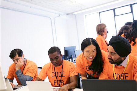 Hackers at laptops coding for charity at hackathon Photographie de stock - Premium Libres de Droits, Code: 6113-09168668