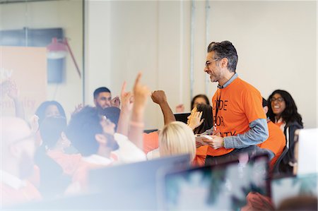 Man leading cheering hackers coding for charity at hackathon Foto de stock - Sin royalties Premium, Código: 6113-09168608