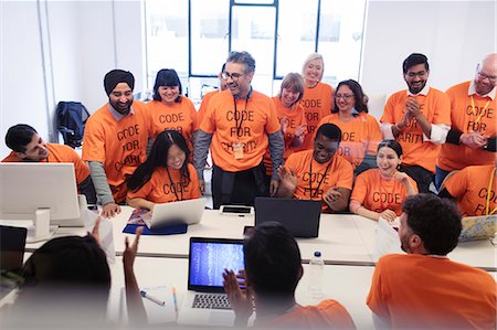 Hackers coding for charity at hackathon Foto de stock - Sin royalties Premium, Código: 6113-09168620