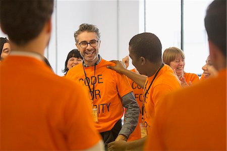 Happy hackers coding for charity at hackathon Stock Photo - Premium Royalty-Free, Code: 6113-09168626