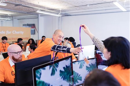 Hackers with lanyard, coding for charity at hackathon Stock Photo - Premium Royalty-Free, Code: 6113-09168635