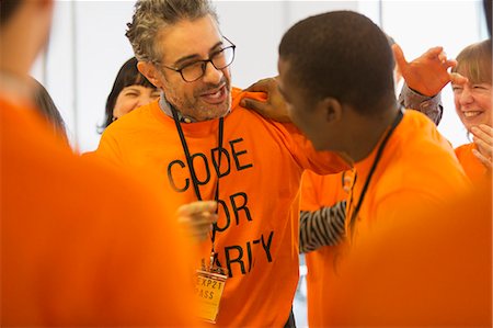 simsearch:614-06311939,k - Happy hackers hugging, coding for charity at hackathon Stock Photo - Premium Royalty-Free, Code: 6113-09168639