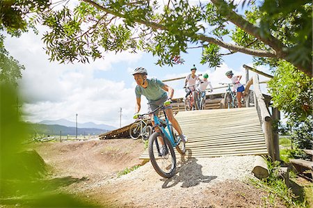 simsearch:6113-08171340,k - Man mountain biking down sunny obstacle course ramp Stock Photo - Premium Royalty-Free, Code: 6113-09168853