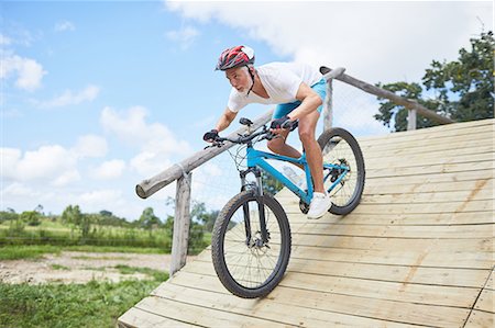 simsearch:400-06922980,k - Focused mature man mountain biking down obstacle course ramp Stock Photo - Premium Royalty-Free, Code: 6113-09168850