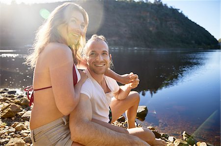 simsearch:6113-09272522,k - Portrait affectionate, carefree couple holding hands at sunny summer lake Fotografie stock - Premium Royalty-Free, Codice: 6113-09168873