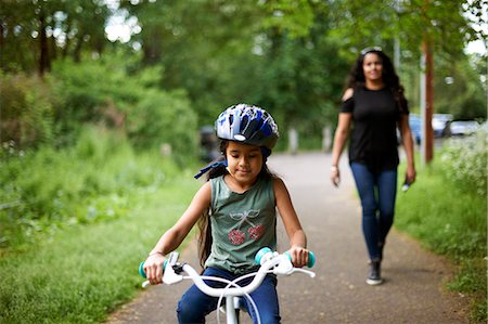 simsearch:6113-07242420,k - Mother watching daughter bike riding on path Photographie de stock - Premium Libres de Droits, Code: 6113-09168887