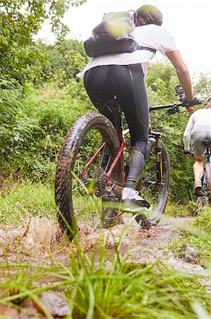 riding bicycles hispanic - Woman mountain biking on muddy trail Stock Photo - Premium Royalty-Free, Code: 6113-09168834