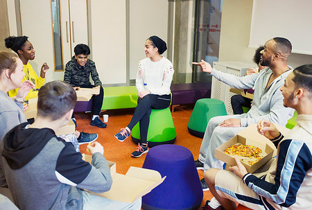 school boy sitting cross legged - Teenagers and mentor talking and eating pizza in community center Stock Photo - Premium Royalty-Free, Code: 6113-09178556