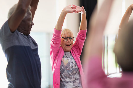 simsearch:6113-09178594,k - Smiling active seniors exercising, stretching arms Foto de stock - Royalty Free Premium, Número: 6113-09178584