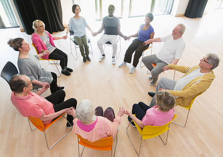 Active seniors holding hands in circle, meditating in community center Stock Photo - Premium Royalty-Free, Code: 6113-09178617