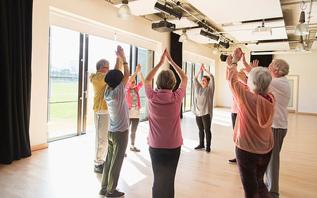 simsearch:6113-09178594,k - Active seniors exercising, stretching arms overhead in circle Foto de stock - Royalty Free Premium, Número: 6113-09178627