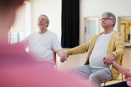 senior community living centers - Serene active senior men holding hands, meditating in community center Stock Photo - Premium Royalty-Free, Code: 6113-09178631