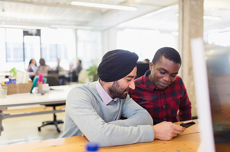 Businessmen using smart phone in office Stock Photo - Premium Royalty-Free, Code: 6113-09178706