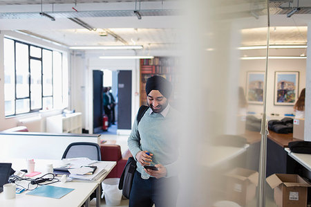 share work space - Indian businessman in turban using smart phone in office Stock Photo - Premium Royalty-Free, Code: 6113-09178715