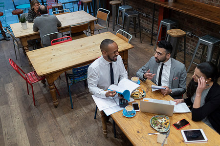 person holding up sign - Business people talking and eating, working in cafe Stock Photo - Premium Royalty-Free, Code: 6113-09178812