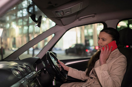 Businesswoman talking on smart phone in car at night Stock Photo - Premium Royalty-Free, Code: 6113-09178833