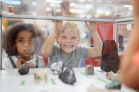 Silly girl making a face at rock exhibit display case in science center Photographie de stock - Premium Libres de Droits, Code: 6113-09178904