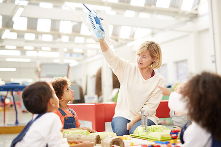 simsearch:6113-07731163,k - Curious kids watching teacher with toy airplane in science center Stock Photo - Premium Royalty-Free, Code: 6113-09178936