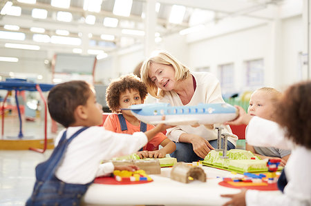 Teacher showing toy airplane to kids in science center Stock Photo - Premium Royalty-Free, Code: 6113-09178938