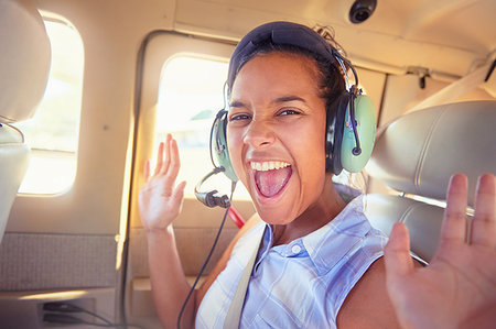 Portrait enthusiastic young woman with headphones riding in airplane Foto de stock - Sin royalties Premium, Código: 6113-09179049