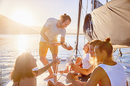 sunset summer food - Friends drinking champagne on sunny catamaran Stock Photo - Premium Royalty-Free, Code: 6113-09179012