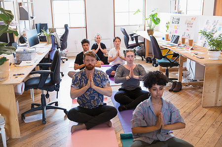 Creative business people meditating in office Stock Photo - Premium Royalty-Free, Code: 6113-09179185