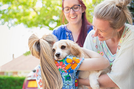 Lesbian couple and daughter hugging cute dog Stock Photo - Premium Royalty-Free, Code: 6113-09191942