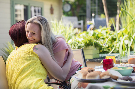 simsearch:6124-09239356,k - Affectionate lesbian couple hugging at lunch patio table Photographie de stock - Premium Libres de Droits, Code: 6113-09191952