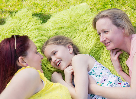 Affectionate lesbian couple and daughter laying in grass Stock Photo - Premium Royalty-Free, Code: 6113-09191930