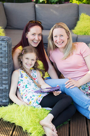 Portrait happy lesbian couple and daughter relaxing on patio Stock Photo - Premium Royalty-Free, Code: 6113-09191937