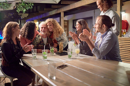 Happy friends clapping, celebrating on patio at night Photographie de stock - Premium Libres de Droits, Code: 6113-09192081