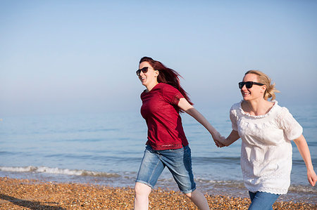 simsearch:649-06489714,k - Affectionate lesbian couple holding hands on sunny beach Stock Photo - Premium Royalty-Free, Code: 6113-09199743