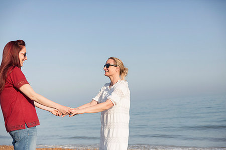 simsearch:649-06489714,k - Affectionate lesbian couple holding hands on sunny ocean beach Stock Photo - Premium Royalty-Free, Code: 6113-09199746