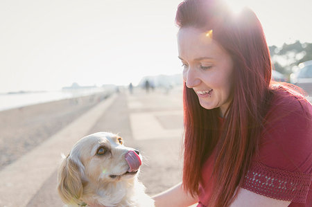 Woman with cute dog on sunny beach boardwalk Foto de stock - Sin royalties Premium, Código: 6113-09199768