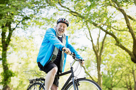 simsearch:6113-09199866,k - Portrait smiling active senior man riding bike in park Photographie de stock - Premium Libres de Droits, Code: 6113-09199782