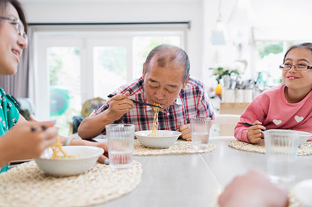 simsearch:6113-09199972,k - Multi-generation family eating noodles with chopsticks at table Foto de stock - Royalty Free Premium, Número: 6113-09199946