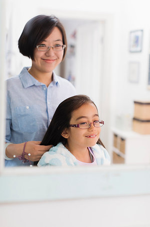 Mother fixing daughters hair in bathroom mirror Stock Photo - Premium Royalty-Free, Code: 6113-09199905