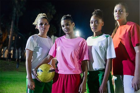 simsearch:614-08875693,k - Portrait confident, tough young female soccer team with soccer ball on field at night Foto de stock - Royalty Free Premium, Número: 6113-09111860